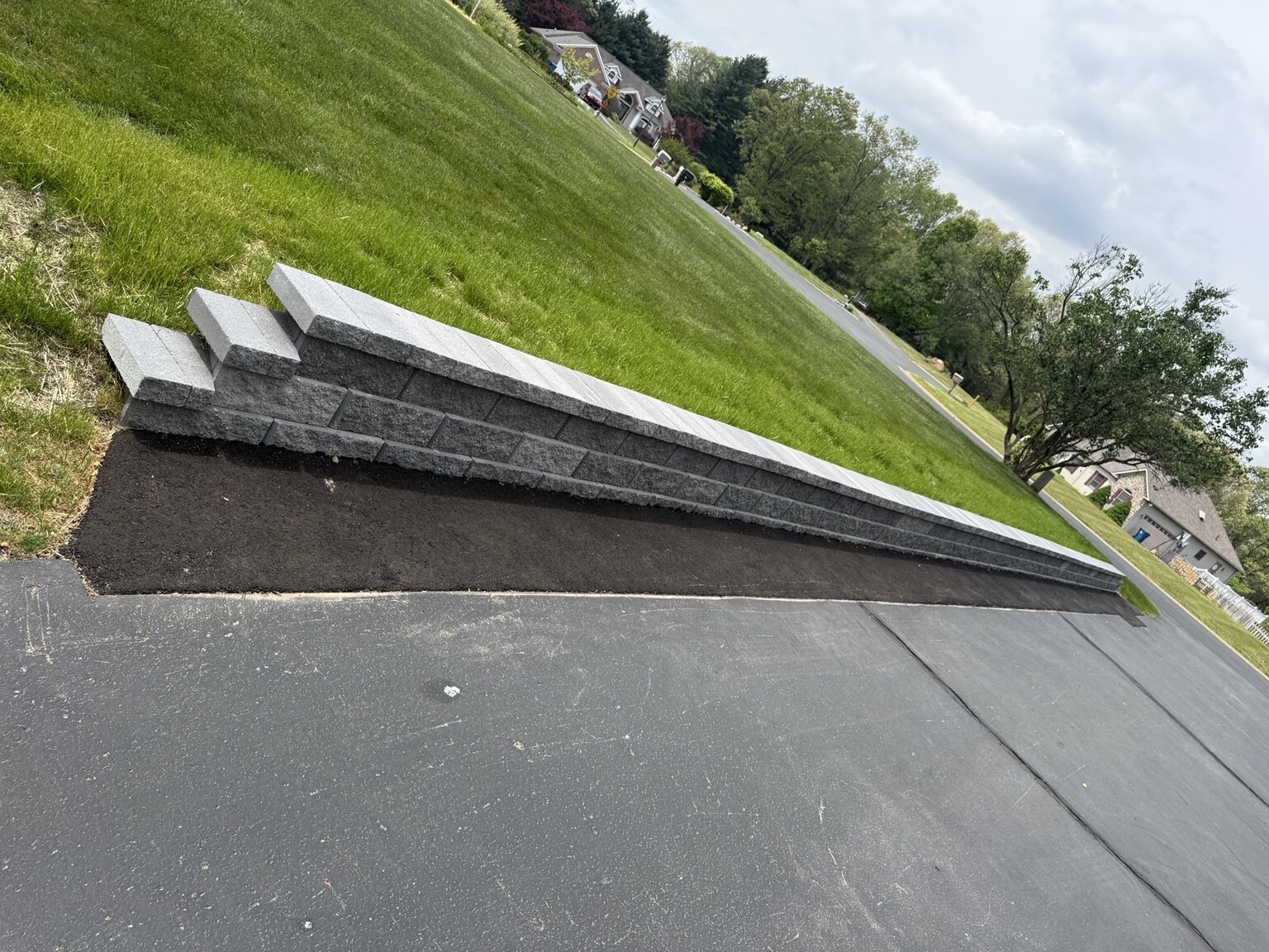 Full completed Leatherman Hardscape retaining wall along a residential driveway